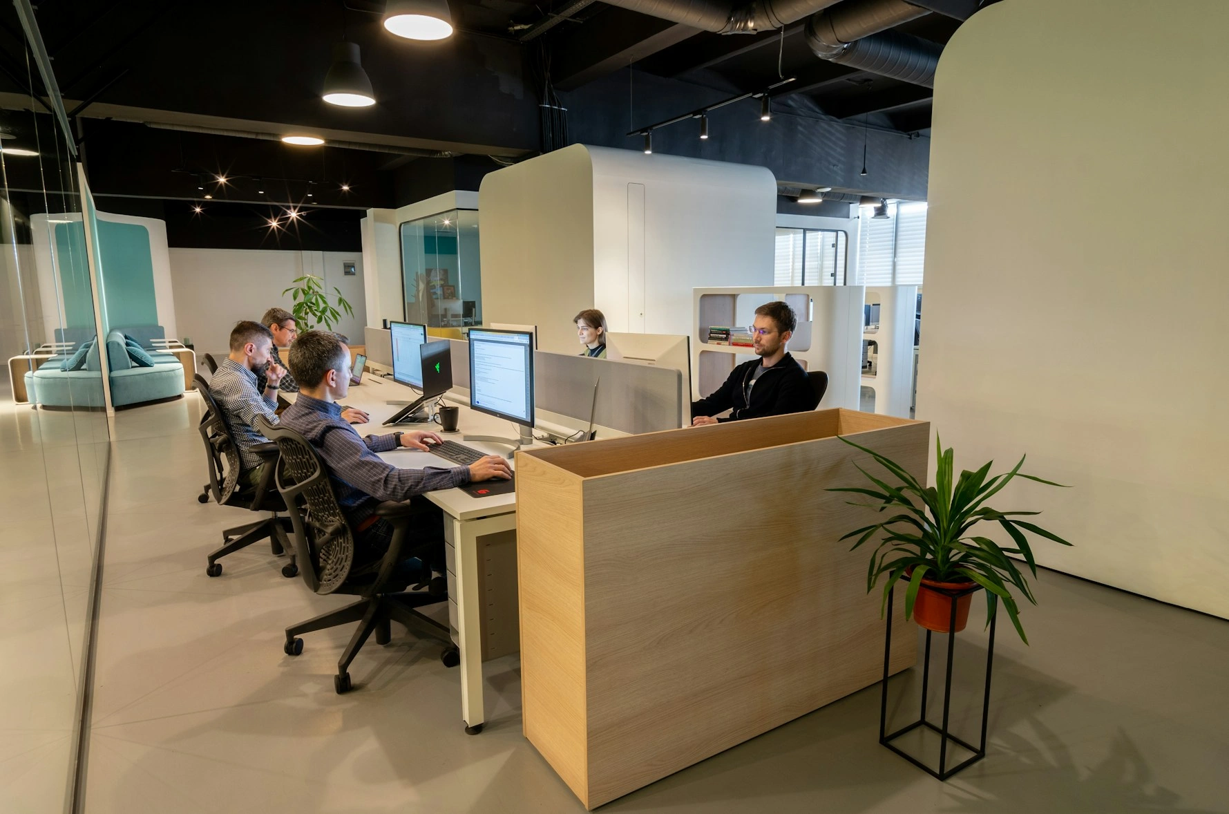 A row of engineers at work along a shared desk in the office